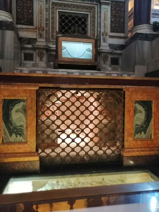 За решеткой видна боковая часть саркофага, наверху - цепь, в которую был закован Апостол