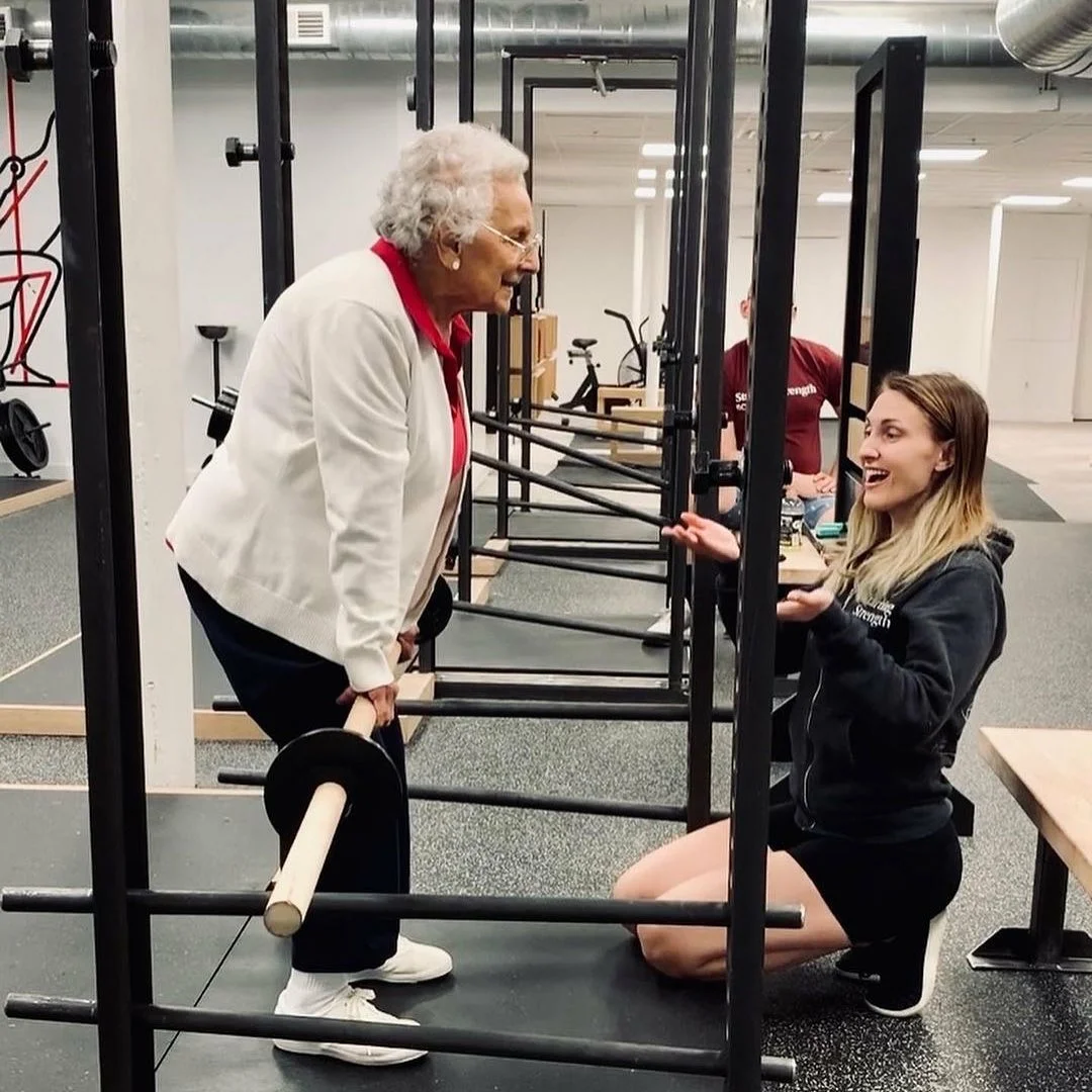 Бабушка выполняет становую тягу с ПВХ трубой на комфортную ей амплитуду. Это тренеры Starting Strength. всех с улицы загоняют под штангу. Это чтобы я не слышал отмазок "мне уже не 18 лет чтоб лезть под штангу" 