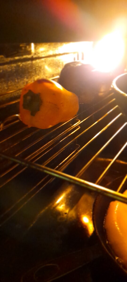 Как только перец смякнет и на нем местами появится запекшая корочка, перекладываем его в кастрюльку для остывания и лучшего снимания корочки.