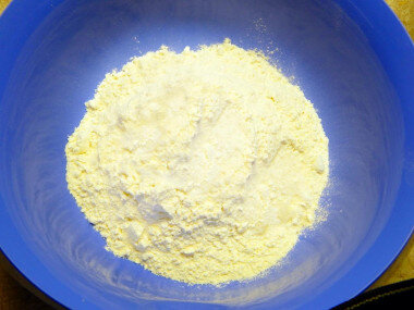 Приготовим ингредиенты для выпечки лепешек. Их совсем немного. Пшеничную муку просеиваем и всыпаем в глубокую миску. Добавляем к муке разрыхлитель и соль. Перемешиваем сухие ингредиенты.