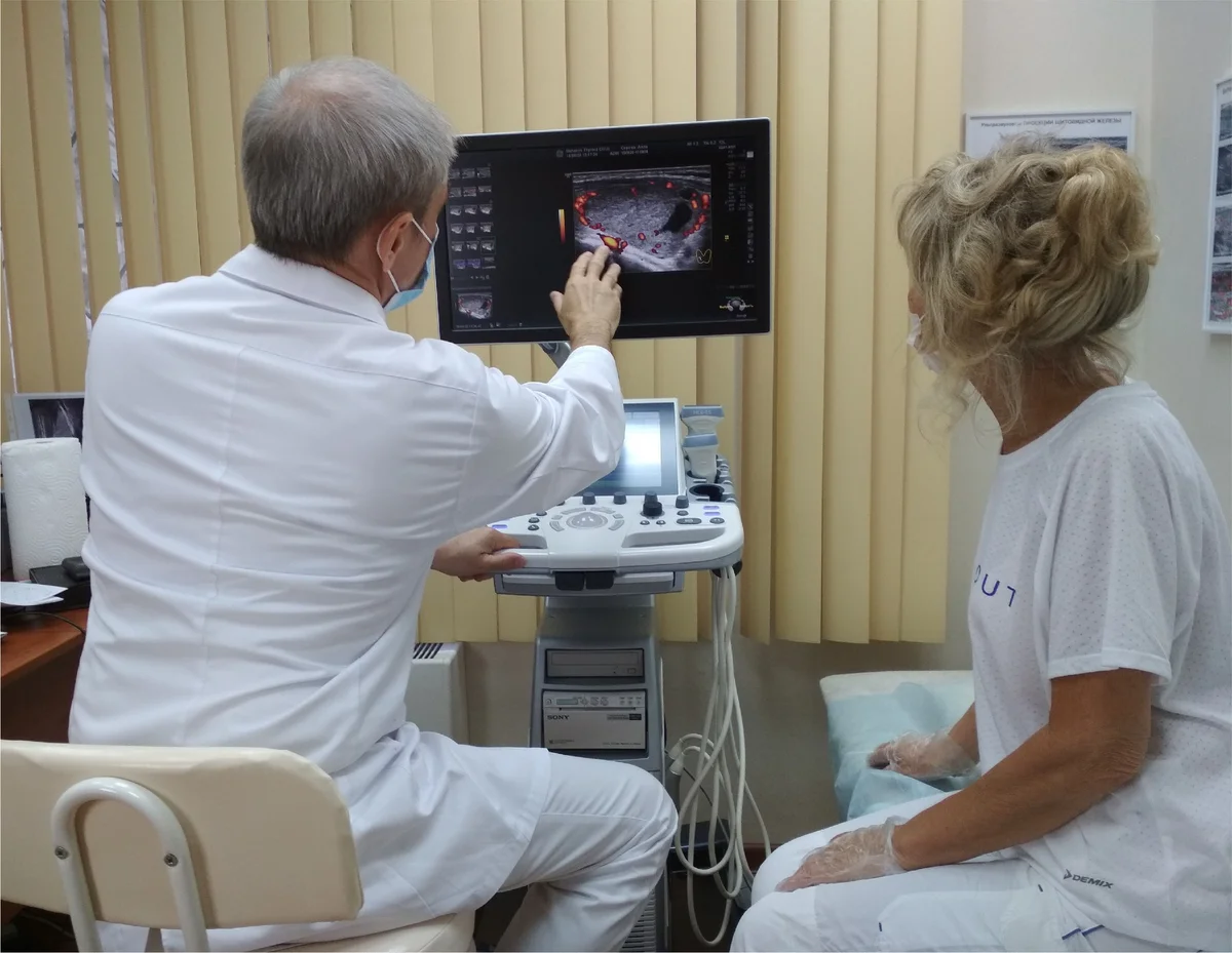 Доктор Ушаков показывает снимки УЗИ щитовидной железы и рассказывает пациентке о состоянии ее эндокринного органа 