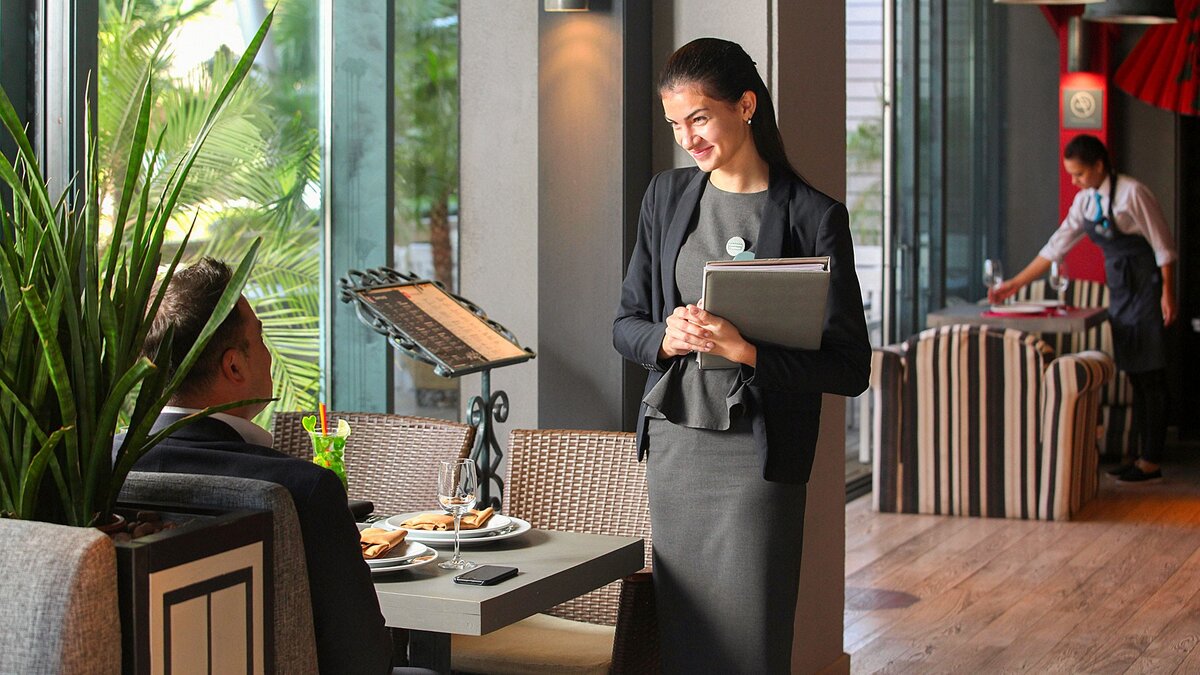 на входе в ресторан гостей встречает. встреча гостей в ресторане хостес. на входе в ресторан гостей встречает. метрдотель. персонал гостиницы.