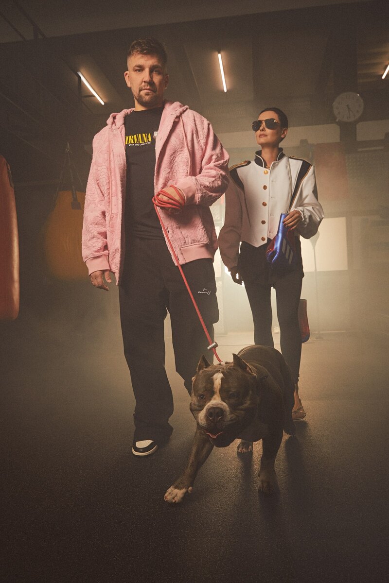ВАСИЛИЙ И ЕЛЕНА СО СВОИМ АМЕРИКАНСКИМ БУЛЬДОГОМ ПЕРСИКОМ. НА ВАСИЛИИ: ХЛОПКОВЫЙ КАРДИГАН, PRADA; ХЛОПКОВАЯ ФУТБОЛКА, OTHER. ЗДЕСЬ И ДАЛЕЕ: КОЖАНЫЕ КРОССОВКИ, NIKE. НА ЕЛЕНЕ: ЖАКЕТ ИЗ ХЛОПКА И ШЕРСТИ, СОЛНЦЕЗАЩИТНЫЕ ОЧКИ, ВСЕ LOUIS VUITTON; ШОРТЫ ИЗ ПОЛИАМИДА И БОКСЕРСКИЕ ПЕРЧАТКИ, ВСЕ ADIDAS; ЛЕГИНСЫ ИЗ ПОЛИАМИДА, NIKE; КОЖАНЫЕ БОСОНОЖКИ, JIMMY CHOO.