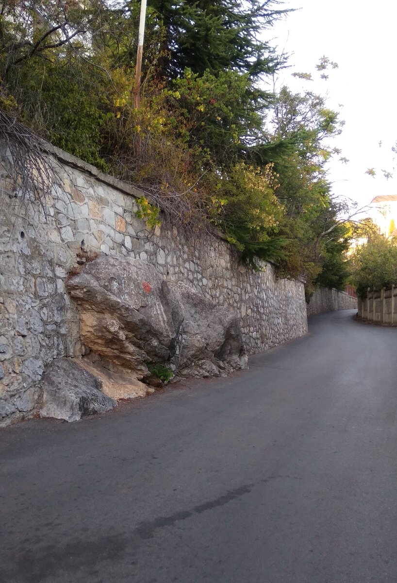 При строительстве подпорной стенки не стали вырубать скалу (при этом дорога очень узкая, можно об камень и машину поцарапать)