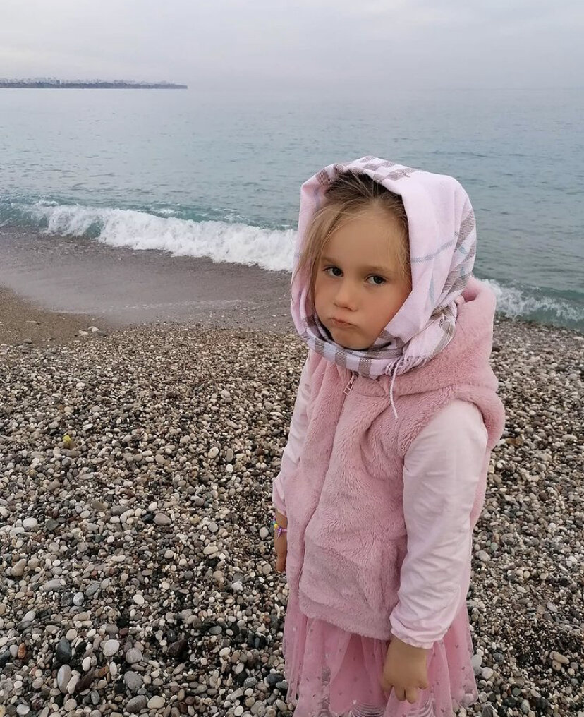 Дочка недовольная, потому что дергаю её для фотографий и не даю кидать камни в море😂