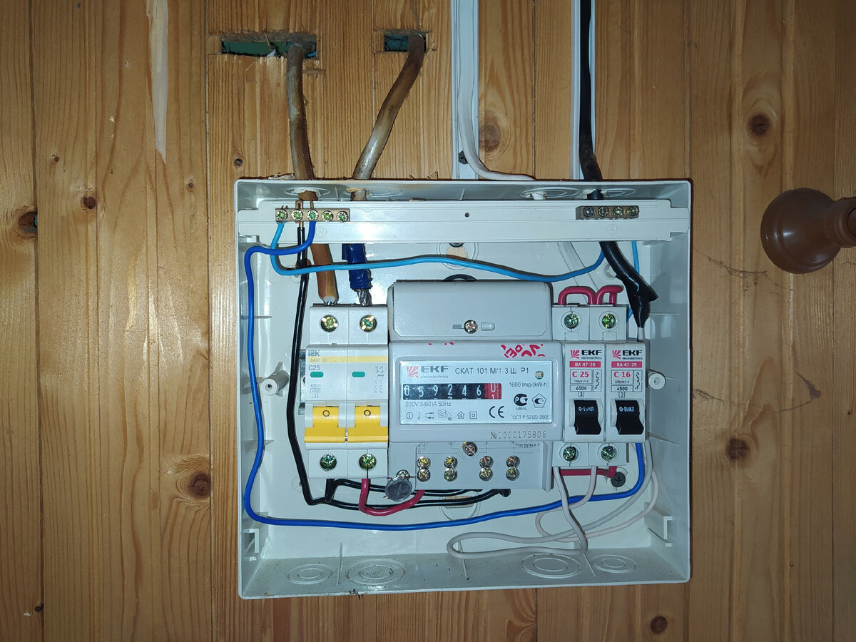 Два алюминиевых провода заходят через стену на автоматический выключатель.