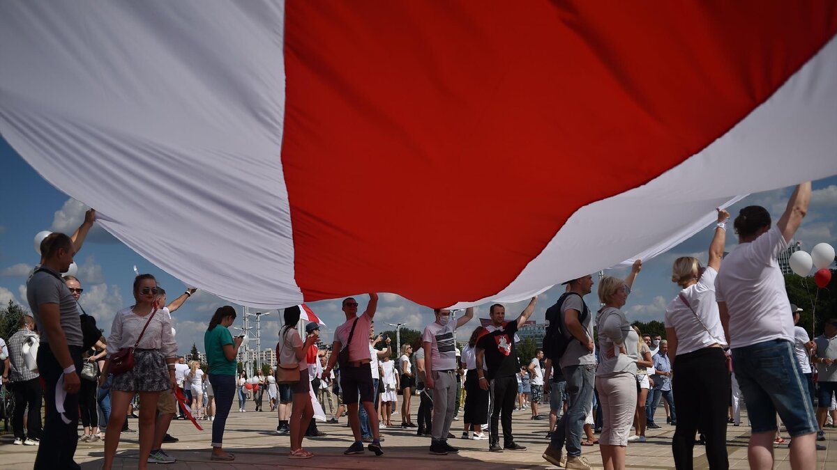 Бело-красно-белый флаг на протестах в Минске 
Фото: Getty Images