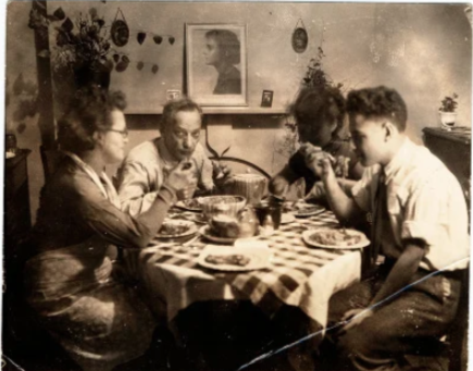 Ужин в квартире Бассмана на Восточной 13-й улице в Манхэттене, декабрь 1933 года. Слева направо: Клара, Джулиус, Лилиан и Пол. Позже Лилиан что-то нацарапала на лице. Юлиус Бассман (1883–1938), маляр и коммунист, родился в Вильнюсе, Литва. Соня недавно уехала в Россию; ее портрет стоит на каминной полке