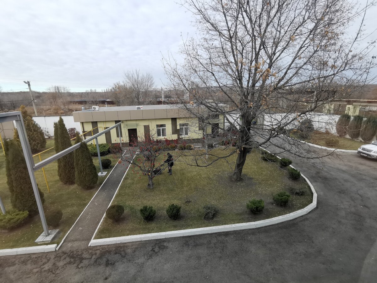 Ухоженная территория производства. Работает газонокосильщик.