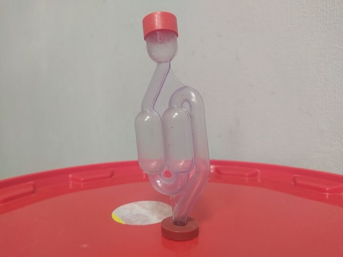 Гидрозатвор. В него нужно наливать немного воды.