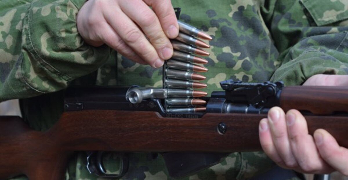 перезаряжает пистолет. винтовка мосина 10 зарядная.