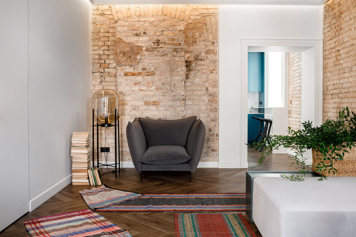 Мягкую группу распределили по комнате — диван и кресло расположили в противоположных углах, сохранив достаточно место для прохода.