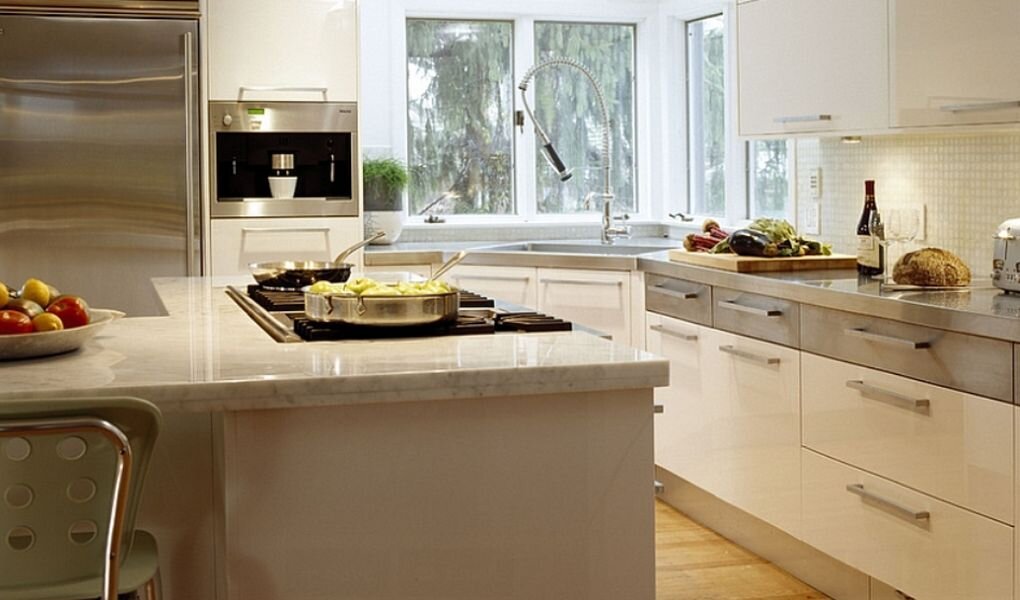 Серо-белая кухня с угловой мойкой.