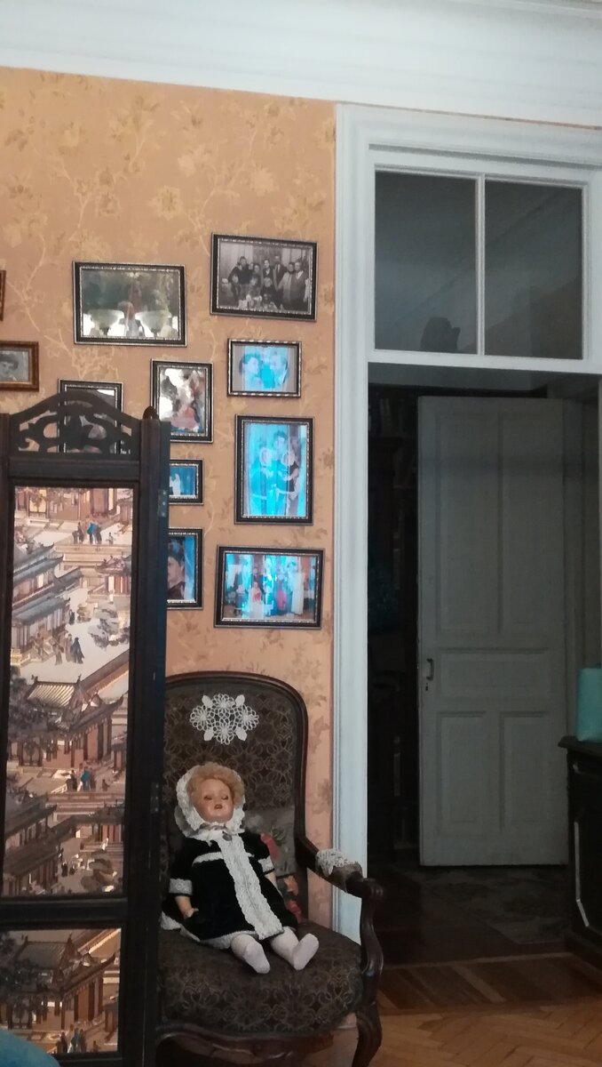 Эта комната служит одновременно и спальней, и гостиной. На стене видны фотографии нескольких поколений семьи, проживавшей в этой квартире.