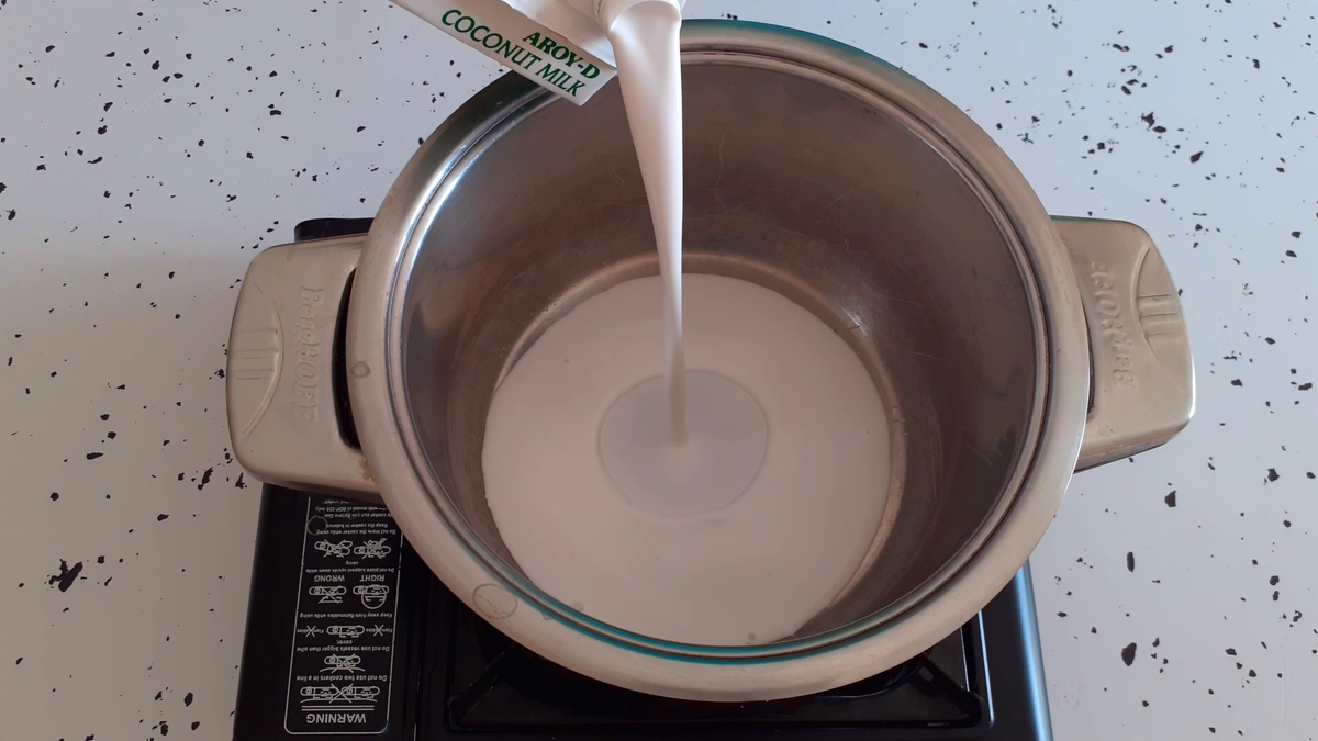 All coconut milk is poured into a saucepan with a thick bottom. It is very important to use high-quality coconut milk to make desserts delicious. I turn on the fire and bring the coconut milk to a boil. As soon as the first bubbles appear, the milk is ready for use.