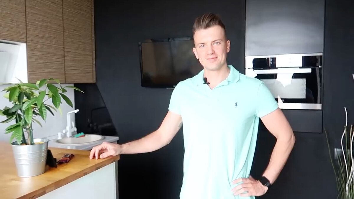 Юрий на своей кухне с черной стеной с секретом