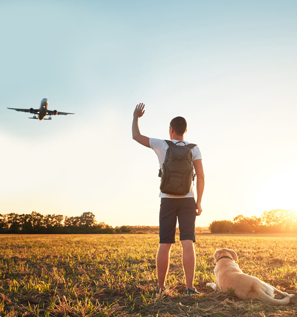 Saying hello at the sunset. Young man with his dog on the evening walk along the airport.