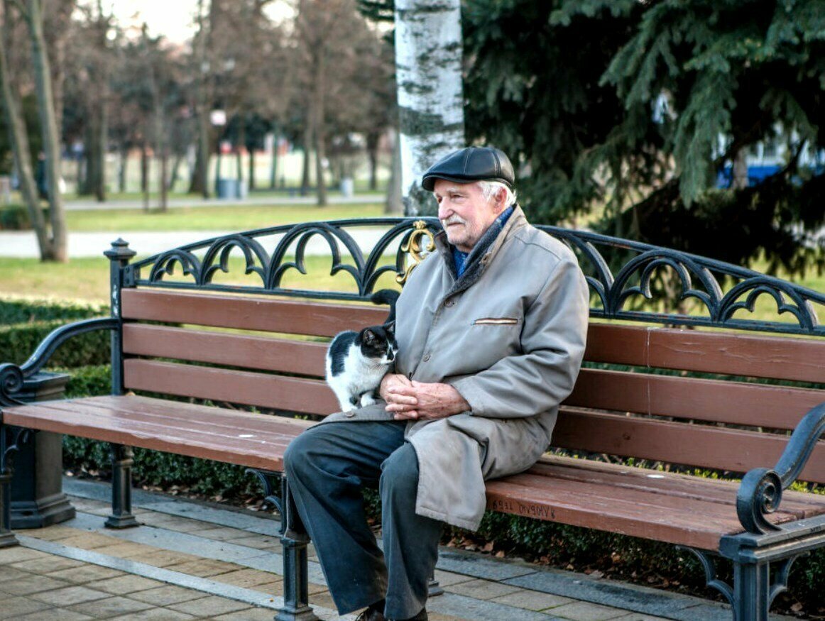 Старик сидит на скамейке