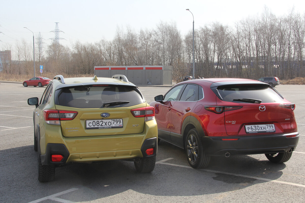 Subaru XV против Mazda CX-30: сзади оба автомобиля симпатичные. Но Мазда СХ-30 смотрится больше как хэтчбэк, а Субару ближе к кроссоверам. Тому причина и высокий дорожный просвет у XV.