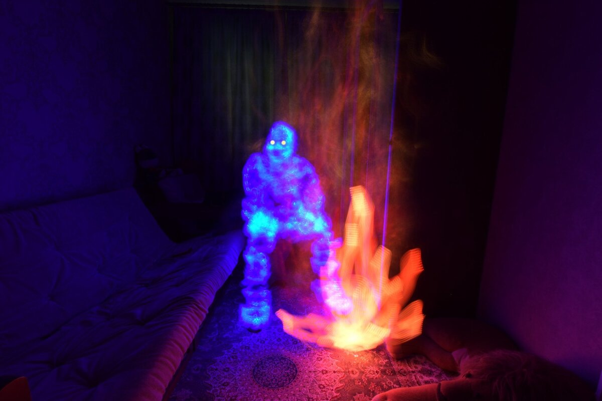 Человек у костра в квартире)))  Костёр рисовал прямоугольным rgb светильником для видеосъемки, "дым" или "искры" над костром оптоволоконная метёлка от домашнего настольного светильника. "Человек" - карманный rgb фонарик. Фризлайт.