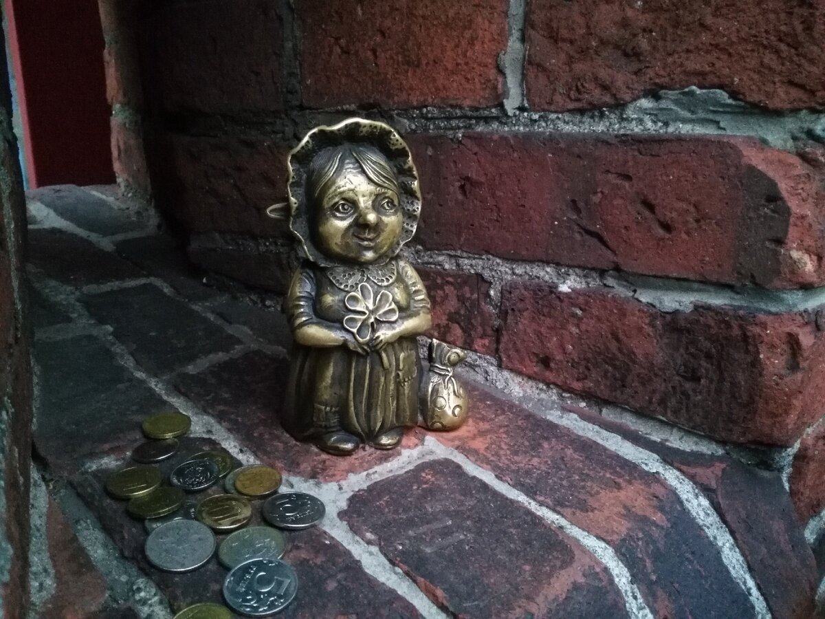 Бабушка Марта, туристы оставляют ей монетки, а взамен трут её мешочек на счастье