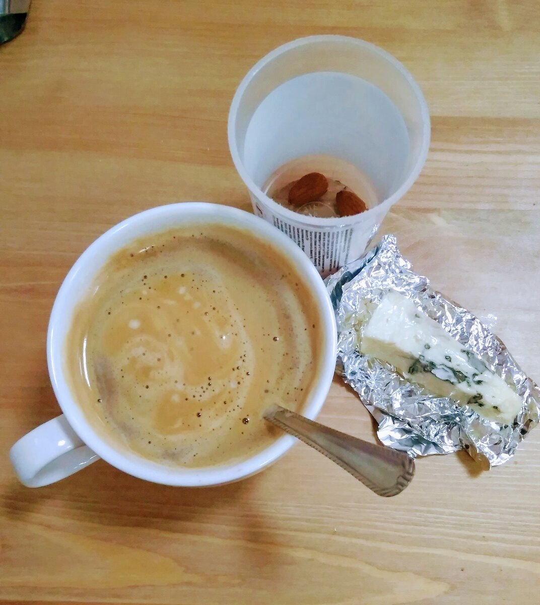 Второй завтрак в офисные времена: черный кофе, кусочек сыра, несколько орешков.