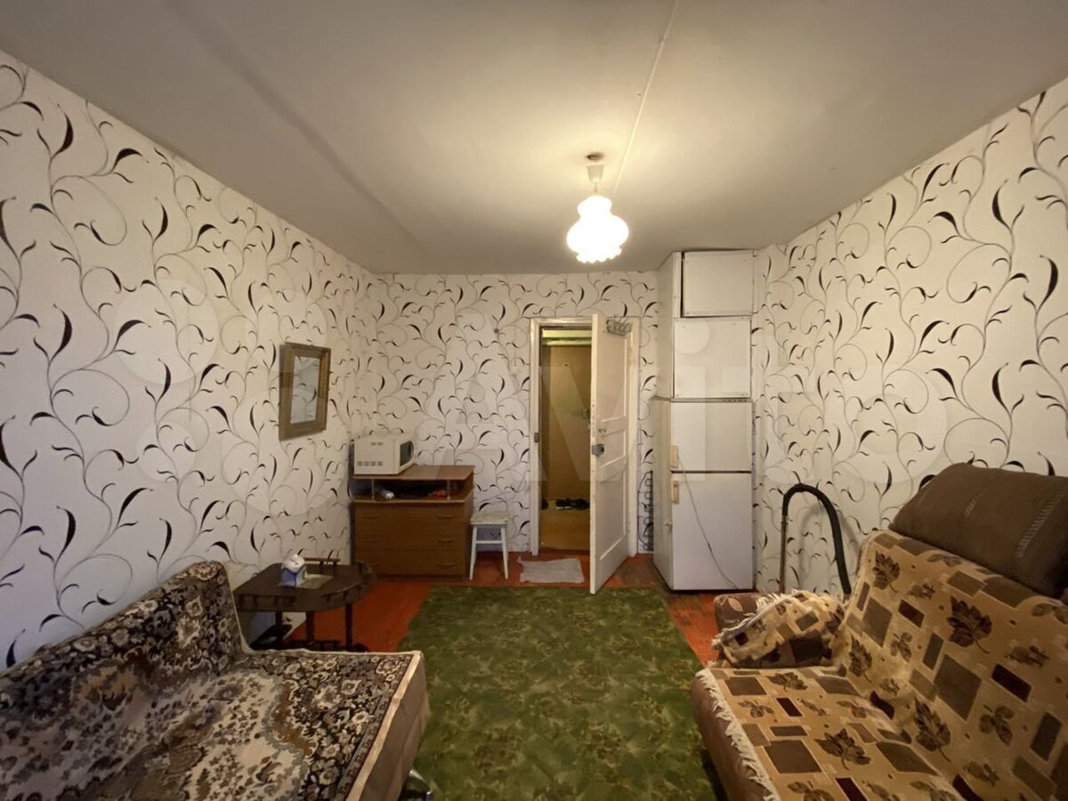 В этом интерьере прекрасно все или пособие по эклектике. Относительно современные обои перекликаются с ковровыми накидками, крашеный суриком пол стыдливо прикрывает палас сдержанного болотного оттенка. Довершают картину поставленные друг на друга два холодильника.