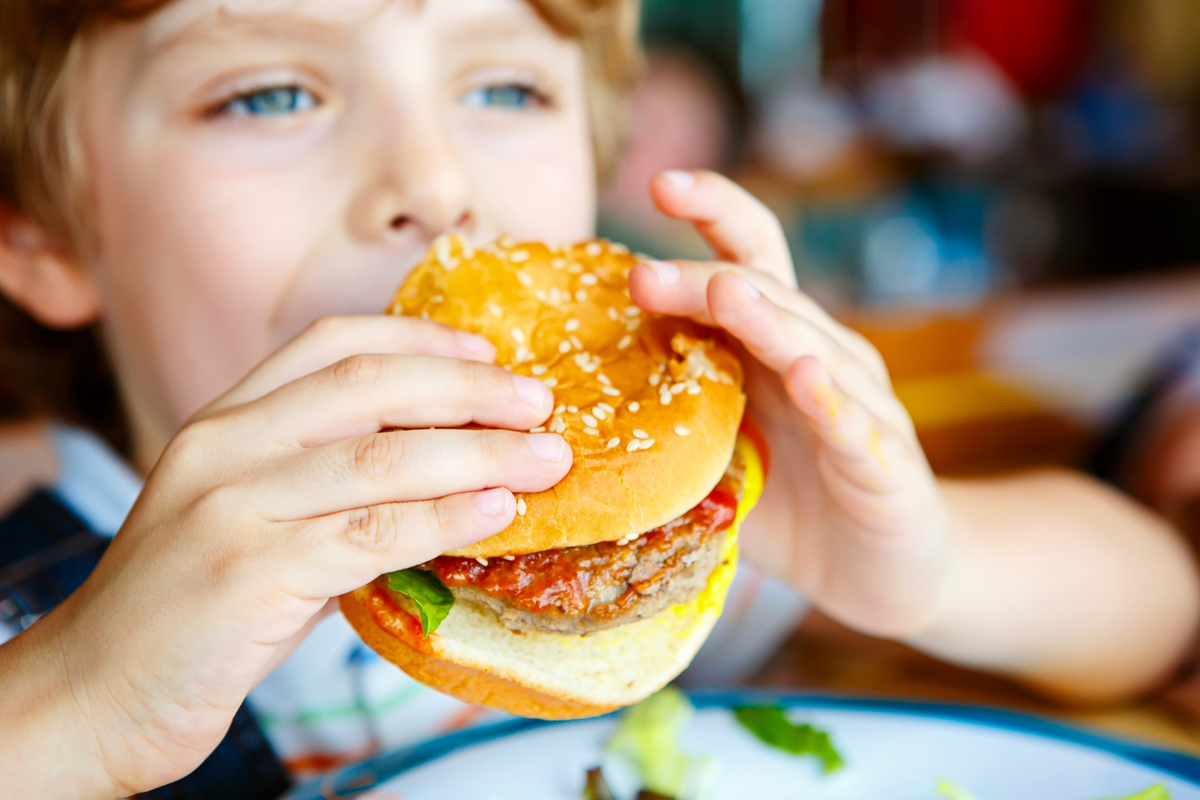 Неправильное питание. Бургер для детей. Мальчик ест гамбургер. Школьники с фастфудом. Гамбургер ребенку