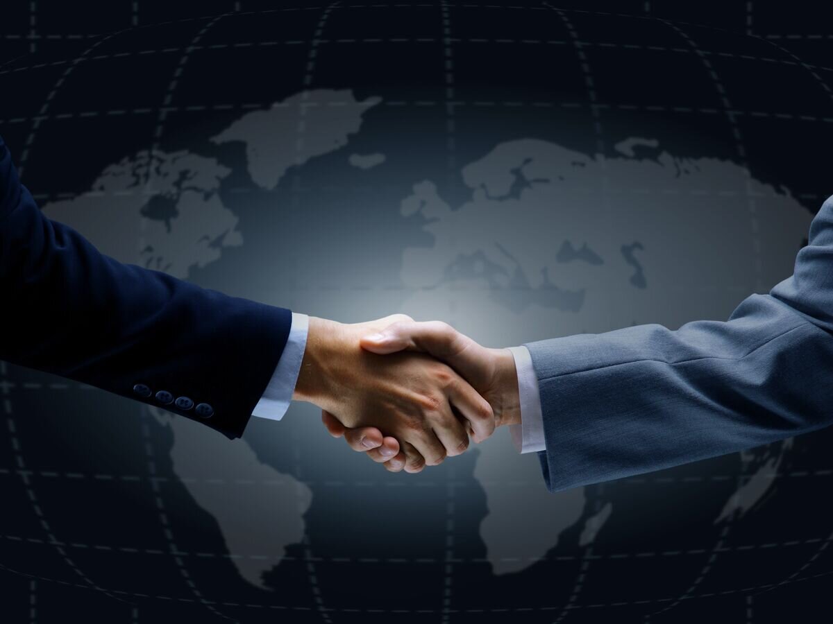    Рукопожатие на фоне карты мира© Fotolia / FotolEdhar