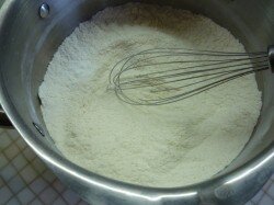 ШАГ 2:
В подходящих размерами миску всыпьте просеянную через мелкое сито муку. Добавьте сахар, соль, разрыхлитель. Все перемешайте с помощью венчика так, чтобы не было комочков. Посуда и венчик должны быть сухими! Отделите желтки от белков. Уберите белки в холодильник, пусть они там постоят и охладятся немного. Чем холоднее будут белки, тем проще будут взбиваться.