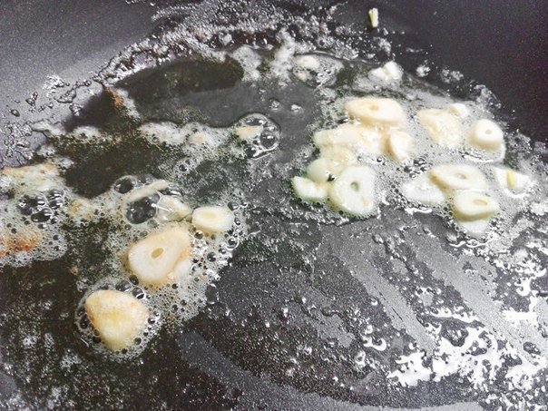 Чистим и режем чеснок. Разогреваем на сковороде сливочное масло и отправляем чеснок обжариваться.