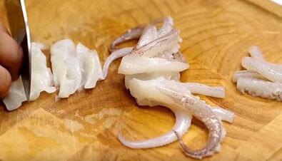 Если вы уже готовы приступить к процессу приготовления нашего блюда, значит у вас есть набор морепродуктов, так необходимых для этого. Лучше всего, конечно покупать готовые наборы морепродуктов, которые продаются в супермаркетах, в замороженном виде. Остается лишь их предварительно разморозить, хорошо ополоснуть холодной водой и можно начинать кулинарное колдовство. Первым берем осьминога и режем длинными ломтиками, откладываем в сторонку.