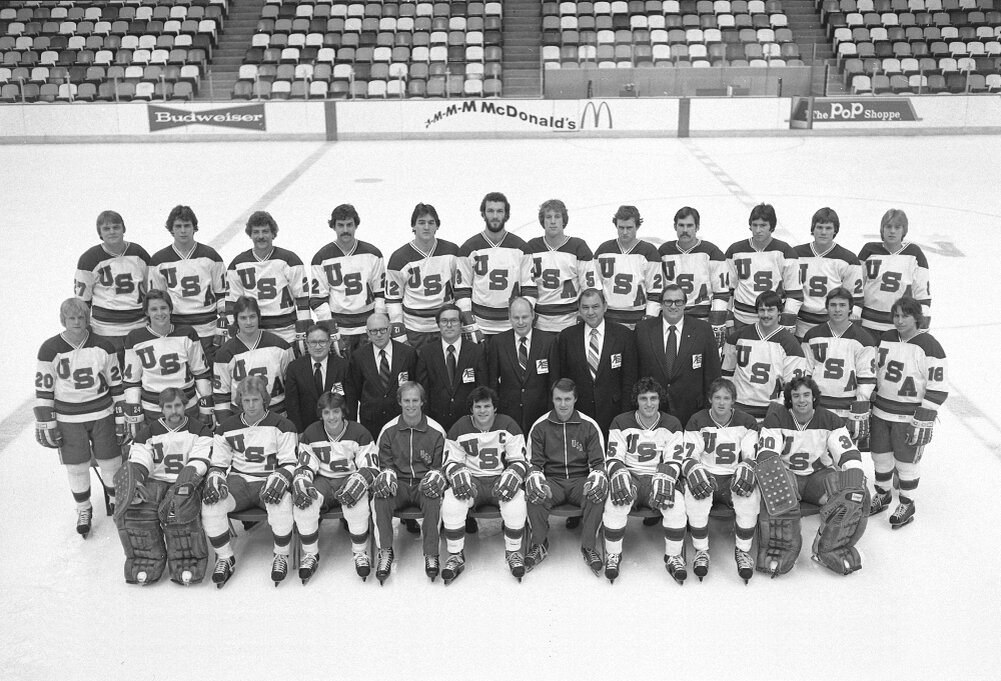 1980 год. Сборная США перед началом Олимпийского турнира: Верхний ряд: Фил Веркота, Стив Кристофф, Лес Ауге, Дейв Делич, Джек Хьюз, Кен Морроу, Майк Рэмзи, Дэйв Кристиан, Ральф Кокс, Дэйв Силк, Джон Харрингтон, Эрик Стробл. Средний ряд: Боб Сутер, Роб Макклэнахэн, Марк Уэллс, Бад Кессел (менеджер), В.Джордж Нагобадс (врач), Гарри Смит (тренер), Роберт Флеминг (президент), Ральф Ясински (генеральный менеджер), Уоррен Стрелуа (тренер вратарей), Брюс Хорш, Нил Бротен, Марк Павелич. Нижний ряд: Стив Янасак, Билл Бейкер, Марк Джонсон, Крейг Патрик (тренер, помощник генерального менеджера), Майк Эрузионе, Херб Брукс (главный тренер), Базз Шнайдер, Джек О’Каллахэн, Джим Крейг