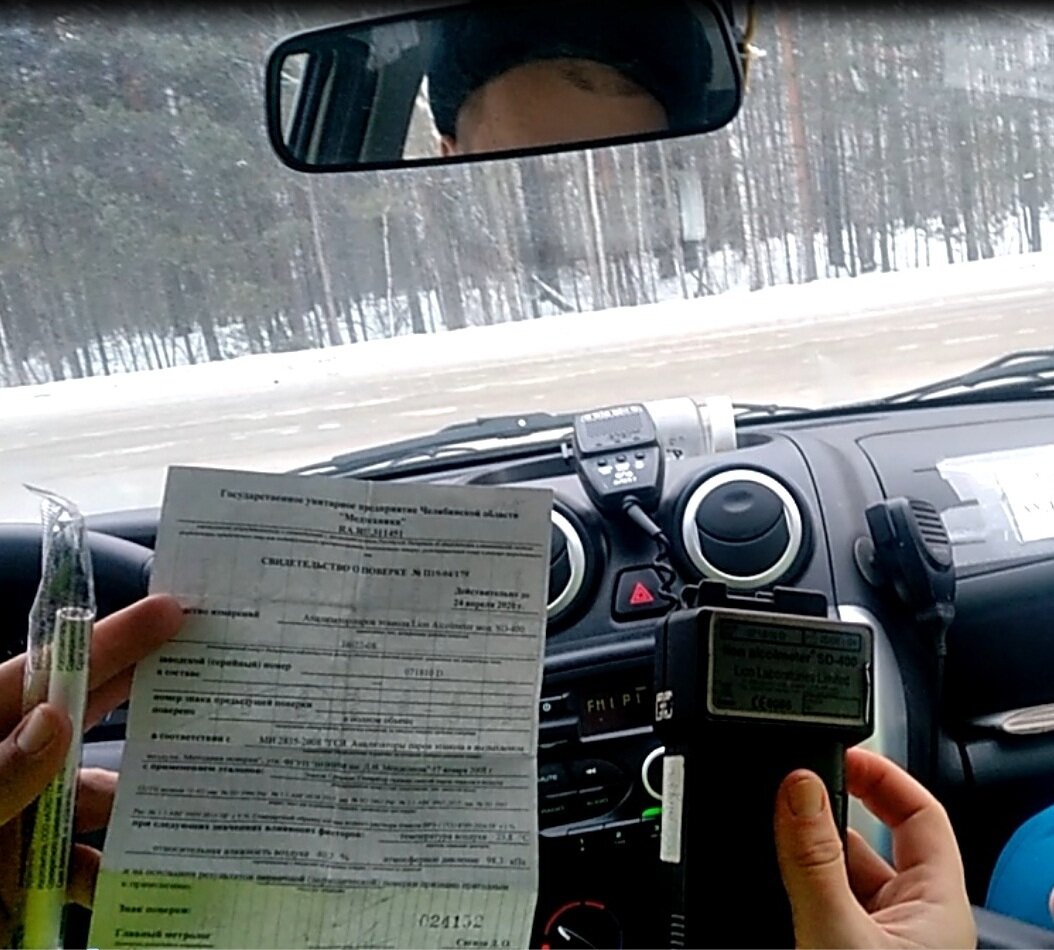 Сотрудник показывает свидетельство о поверке на алкотестер
