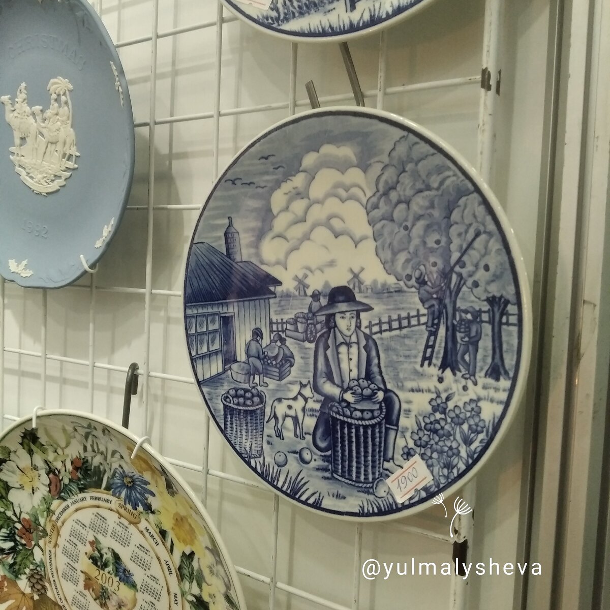 Тарелки от Delft с традиционными голландскими мельницами на заднем фоне 