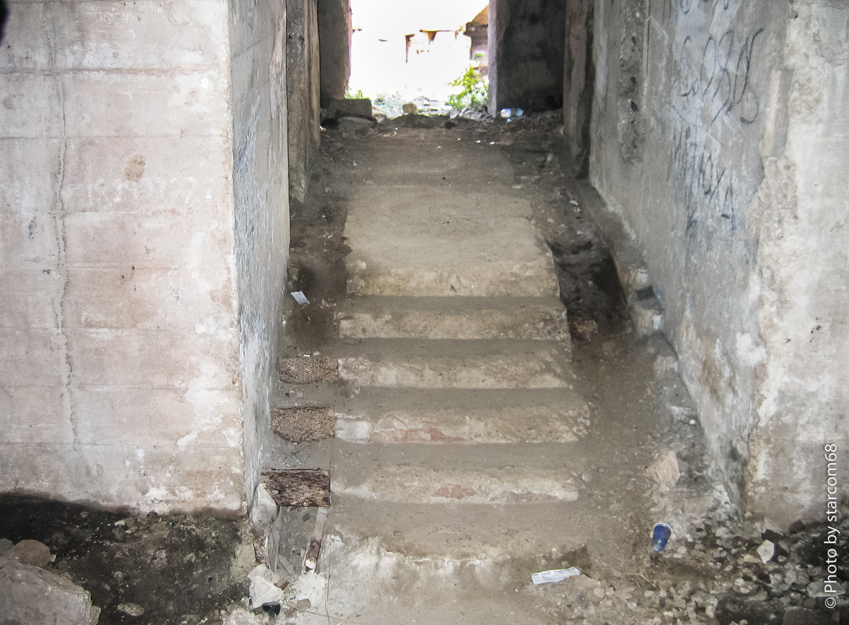 Из тьмы главного коридора артблока по широкому проходу с лестницей, по которому некогда доставлялись боеприпасы в артиллерийские погреба бронебашни № 2, мы направимся к ее открытому сверху и залитому солнцу гнезду, в котором некогда располагалось перегрузочное отделение. На входе в гнездо справа и слева видны проходы в снарядные погреба.