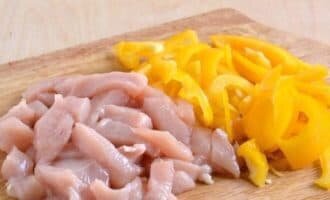 Для начало за час достаньте курицу из холодильника. Я обычно использую грудку. Нарежьте куриную грудку соломкам. Раз говорим о соломке я и морковь и болгарский перец заодно нарезала. Отправьте грудку в глубокую миску. Будем её мариновать.