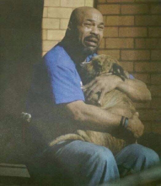 Мужчина обнимает своего пса, который надышался угарным газом. Фотография была сделана сразу же, как пожарный вынес собаку из горящего дома.