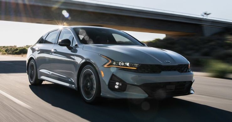 Серый KIA K5 в движении. Источник: Caricos