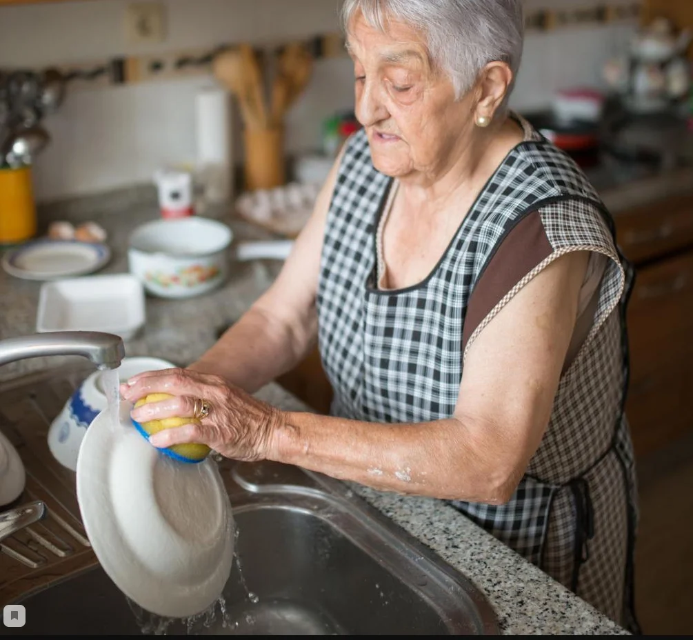 Домашнее хозяйство пенсионерки. Пожилая женщина на кухне. Пожилая женщина моет посуду. Бабушка моется. Женщина моющая посуду.