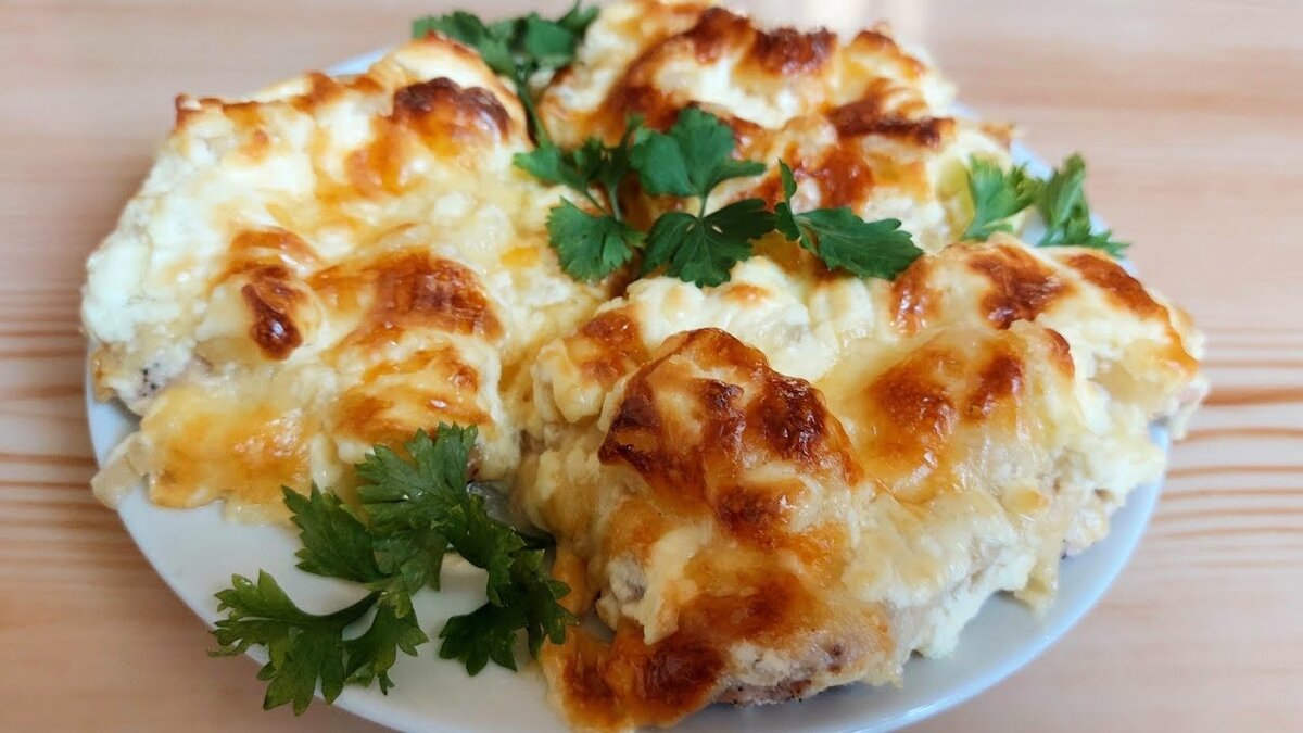 Всем привет! Спасибо, что смотрите наши видео! Сегодня готовлю очень вкусную свинину с ананасами, сыром и вкусным соусом! 
Для приготовления нам понадобится:

Свиной балык - 700 г.
Лук - 2 шт. средние
Чеснок - 2 зубчика крупных
Соль , смесь перцев
Сметана - 3 ст. л.
Майонез - 2 ст.л.
Сыр Сулугуни - 120 г.
Сыр твердый - 150 г.
Ананасы консервир.- 250 г.
Растительное масло - 1 ст л.

Свинину нарезаем на порционные кусочки, шириной 1,2 см, хорошо отбиваем с обеих сторон. Солим, перчим по вкусу и перекладываем в миску.
Лук нарезаем полукольцами, перекладываем к мясу, слегка солим и перчим, мнём его рукой, чтобы лук пустил сок, перемешиваем, накрываем пищевой пленкой и ставим в холодильник мариноваться на 3 часа.
Два вида сыра трем на крупную терку, соединяем и хорошо перемешиваем.
Промаринованное мясо достаем из лука.
Форму, в которой будем запекать, застилаем фольгой, смазываем растительным маслом, выкладываем на дно лук, а сверху кусочки мяса.
На мясо кладем немного сыра.
Сверху на сыр трем на мелкую тёрку чеснок, затем выкладываем консервированные ананасы( у меня кусочками), на ананасы выкладываем оставшийся сыр.
Сметану и майонез смешиваем , перекладываем в кондитерский мешок, делаем небольшой надрез на уголке мешка и выдавливаем сверху на сыр, делая сеточку.
Ставим в разогретую духовку до t°180° выпекаться на 40- 45 минут.
Мясо получается очень мягкое и сочное ,со сладковатым, от ананасов вкусом.
Рекомендую приготовить, Вам очень понравиться! 
Приятного Всем Аппетита!