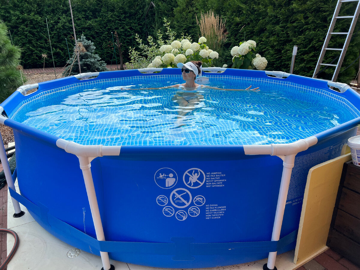 Бассейн стоит на мощении у дома. Плюс - не надо делать отдельную площадку, и нагревается быстрее. Минус - как бельмо на глазу - постоянно на виду