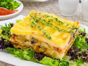 Лук мелко нарезать.Баклажаны нарезать кубиками.
Если баклажаны горькие, их надо посолить, оставить на 30 минут, затем промыть в холодной воде.Кабачки нарезать кубиками.Перец очистить от семян, нарезать кубиками.Сельдерей мелко нарезать.Помидоры нарезать кубиками.На растительном масле обжарить лук.Добавить баклажаны.Добавить кабачки.
Жарить в течение 5–7 минут.Добавить перец.Добавить сельдерей.Перемешать.
Жарить в течение 5 минут.Добавить помидоры.Перемешать.Посолить, поперчить.
Жарить в течение 2–3 минут.Готовим соус бешамель.
Масло растопить.Добавить муку.Перемешать.
Слегка обжарить.Тонкой струйкой влить молоко, хорошо перемешать, довести до кипения.
Нагревать до тех пор, пока соус не станет по консистенции напоминать жидкую сметану.
Главное, следить, чтобы не образовались комочки.
Соус немного посолить, по вкусу можно добавить мускатный орех или чеснок.В форму для запекания (у меня форма 20×30 см и высотой 5 см) выложить листы лазаньи (внимательно прочтите инструкцию на упаковке, некоторые фирмы предлагают листы лазаньи отварить, некоторые — использовать сухие листы).На листы выложить половину овощной начинки.Смазать соусом.Выложить листы.Выложить оставшуюся начинку.Смазать соусом.Выложить листы.Смазать соусом.
Поставить в духовку.
Запекать при температуре 180 градусов в течение 20 минут.Сыр натереть на средней терке.Через 20 минут лазанью посыпать сыром.
Запекать в течение 20–25 минут.Приятного аппетита!