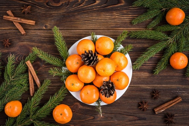 яркие мандарины с шишками и еловыми веточками