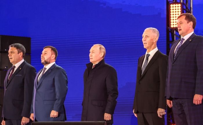    Глава новых субъектов РФ и президент РФ Владимир Путин во время исполнения Гимна Российской Федерации на митинге-концерте «Выбор людей. Вместе навсегда». Фото: Сергей Карпухин, ТАСС/kremlin.ru