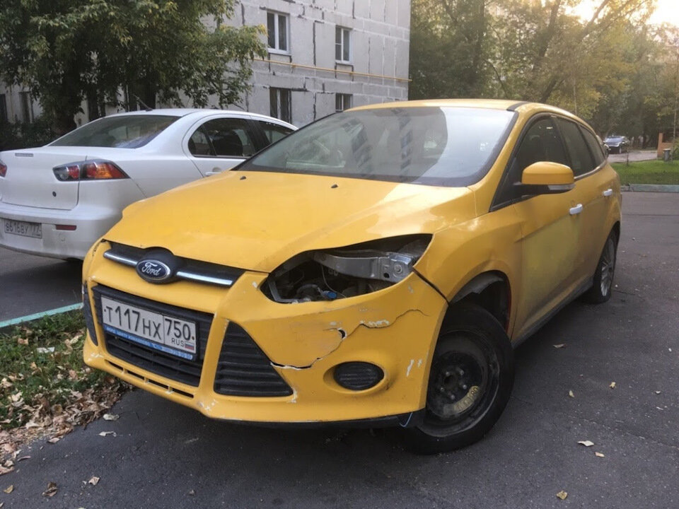 Такси Ford Focus без двигателя и с открытой водительской дверью. 