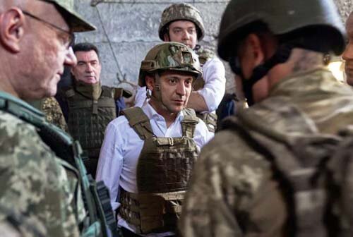 Зеленский в каске и бронежилете на белую рубашку. 