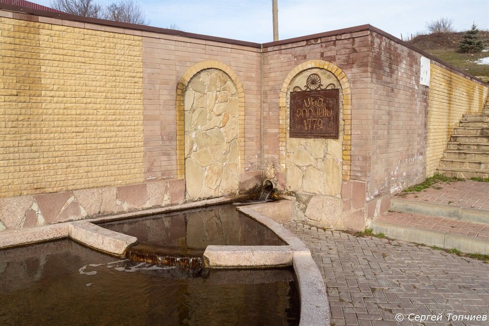 Вот там под памятной табличкой и бьет родник
