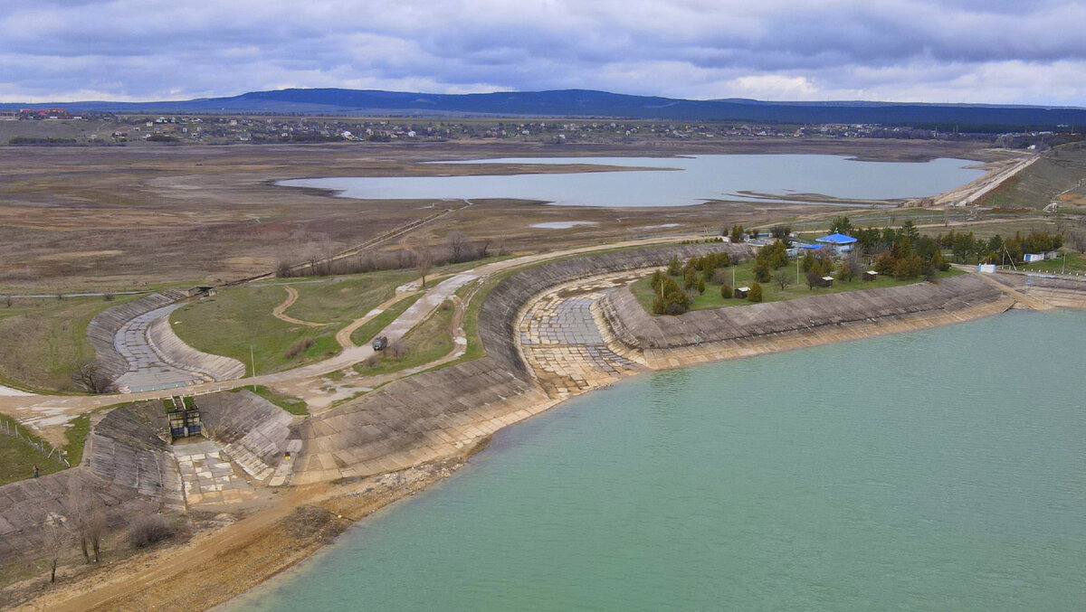 Слева перепускное сооружение для подачи воды в Тайганское водохранилище, справа автоматический водосброс для сброса воды в отводящий канал и далее в р. Биюк-Карасу.
