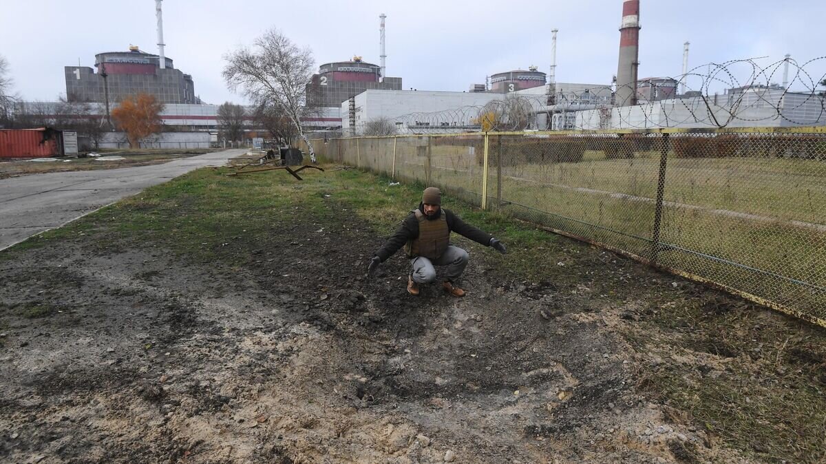    Сотрудник "Росэнергоатома" у воронки от разорвавшегося снаряда на территории Запорожской атомной электростанции после недавних обстрелов со стороны ВСУ© РИА Новости / Алексей Куденко